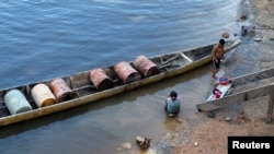 Archivo - Un indígena prepara su canoa para transportar barriles de gas a la zona minera cerca de la población de Parpupik, en el sur de Venezuela, el 16 de noviembre de 2012.