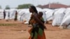 FILE - An Ethiopian asylum seeker carries an infant in the Dambala Fuchana refugee camp near the Ethiopian-Kenyan border town of Moyale, Kenya, March 27, 2018.