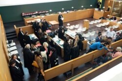 Lawyers speak in the courtroom prior to the start of a trial of a prostitution network case in Lyon, France, Nov. 6, 2019.