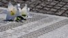 Cvijeće ljiljana položeno na spomen-kameni zid pored imena porodice Husić, na spomen mezarju u selu Potočari, kod Srebrenice, 11. jula 2024.