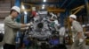 FILE - Men work with an engine at automaker Ford Vietnam's factory in Vietnam's northern Hai Duong province, outside Hanoi June 27, 2014. 