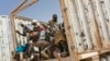 FILE - Migrants climb into a truck to head north into Algeria at the Assamaka border post in northern Niger on June 3, 2018.