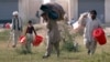 Internally displaced people (IDPs), fleeing a military offensive in South Waziristan, carry handouts outside distribution point for internally displaced persons (IDPs) at Dera Sports Stadium in Dera Ismail Khan, located in Pakistan's restive North West Fr